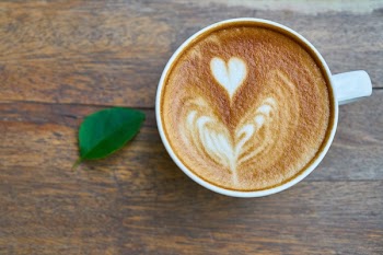 Latte Art and Leaf on Brown Surface