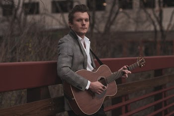 Leaning Man on Handrail While Playing Guitar