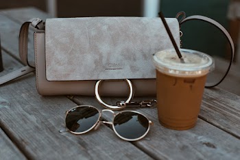 Leather Crossbody Bag Beside Drink And Sunglasses