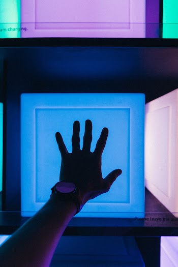 Left Person's Hand Near Blue Board