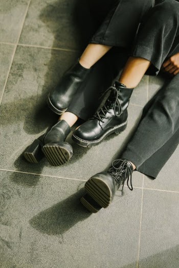 Legs in Black Shoes and Pants of Two Unrecognizable Persons Sitting on Floor · Free Stock Photo