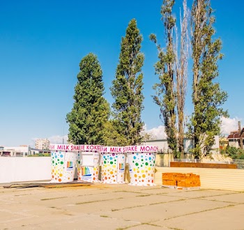 Life-size Milkshake Cups Beside Green Trees