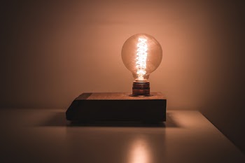 Light Bulb on White Desk Turned on