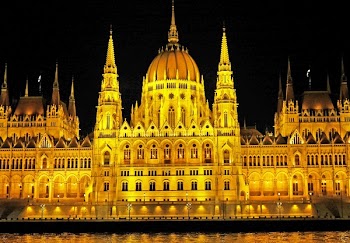 Light Concrete Building Near Body of Water during Night Time