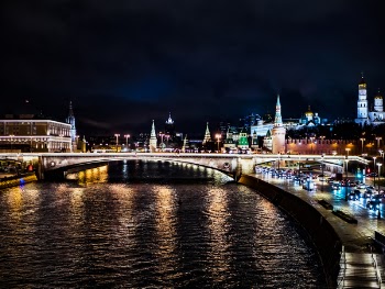 Lighted Bridge Across Body of Water Under Night Sky