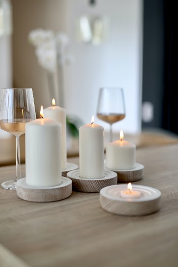lighted candles on wooden table with wine glasses