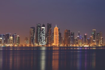 Lighted City Buildings Near Body Of Water 