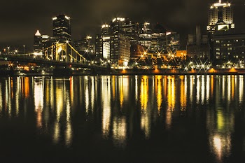 Lighted Gray Concrete Building and Bridge at Night