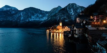 lighted houses near sea and mountain