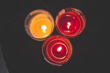 Lighted Red Wax Candle on Clear Drinking Glass