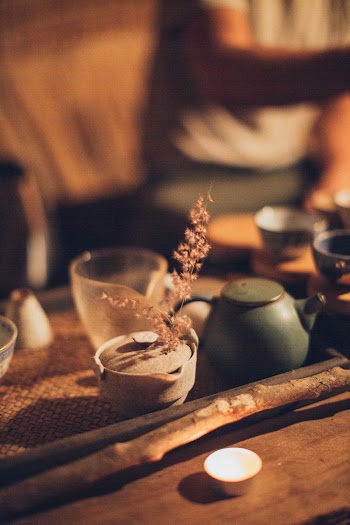 Lighted Tealight Beside Wooden Stick and Ceramic Teapot