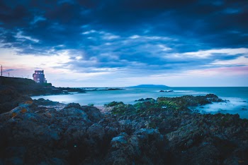 Lighthouse on Cliff Near Sea