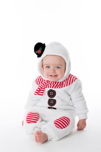 little baby in a snowman costume is looking at camera on white...