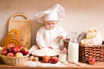 little boy in the cook costume at the kitchen