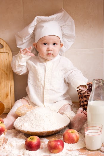 little boy in the cook costume at the kitchen