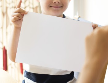 Little boy with a blank paper mockup Free Psd