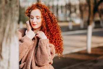 Long Curly Red-haired Woman Wearing Brown Fleece Coat