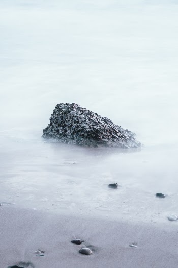 Long exposure shot of a rock on the beach