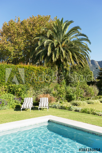 Lounge chairs at sunny luxury poolside