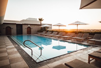 Lounge Chairs With Umbrella Near Swimming Pool