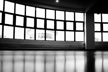 Low-angle and Grayscale Photography of Glass Pane Windows Overlooking Round Building