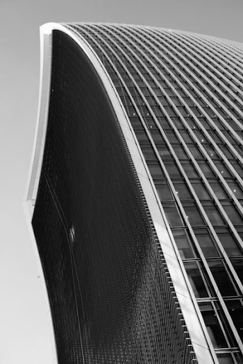 low-angle grayscale photo of curtain-wall building