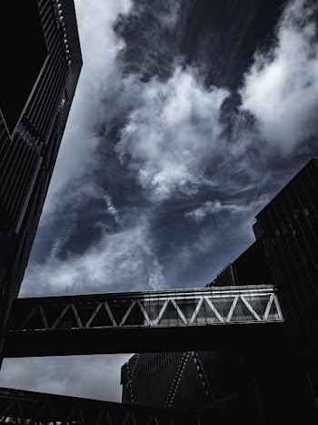 Low-Angle Photo of Connecting Bridge Under Cloudy Sky