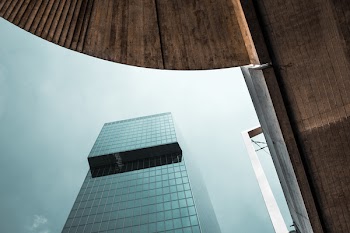 Low-angle Photo of Curtain Building Under White Sky
