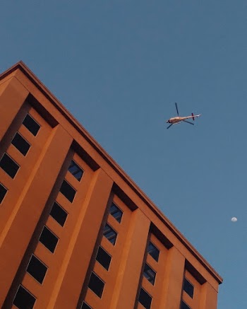 Low-Angle Photo of Helicopter Flying Above Building