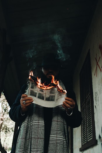 Low-Angle Photo of Man Holding a Burning Paper