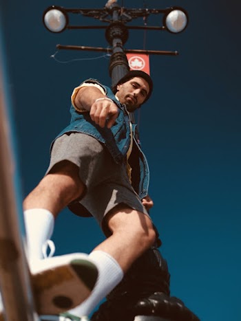 Low-angle Photo of Man Standing Near Light Pole Pointing Down