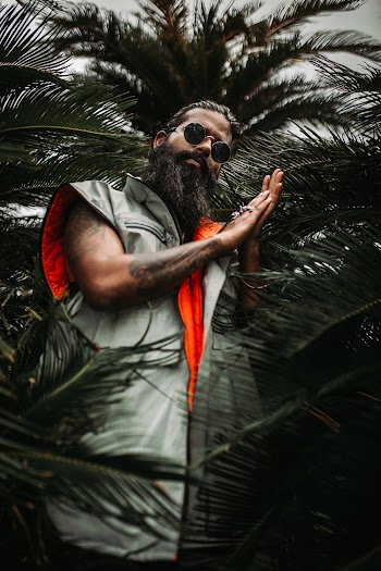 Low-Angle Photo of Man Standing Near Palm Plants