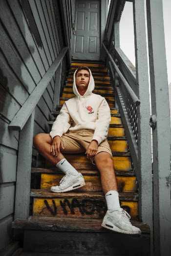 Low-Angle Photo of Man Wearing Hoodie While Sitting on Stairs