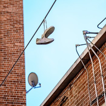 Low Angle Photo of Shoes Hanging on Wire