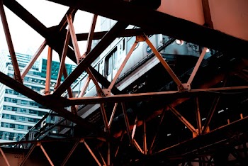 Low Angle Photo of Train on a Metal Bridge Beam