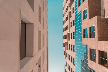 Low angle Photo of Two Concrete Buildings Under Clear Sky 
