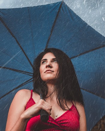 Low-Angle Photo of Woman Holding Blue Umbrella