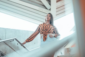 Low Angle Photo of Woman Holding on Handrail