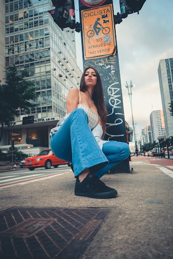 Low Angle Photo of Woman Squat Posing on Sidewalk
