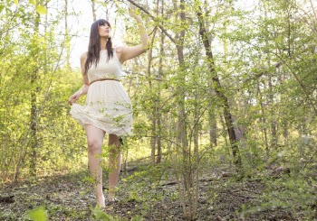 Low Angle Photo of Woman Standing in the Woods Posing While Holding Tree Branch