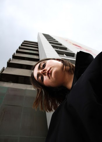 Low-Angle Photo of Woman Standing Near High-Rise Building