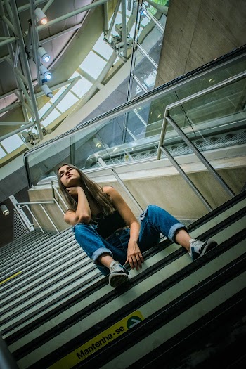 Low Angle Photo of Woman With Her Eyes Closed Sitting on Stairs