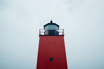 low-angle photograph of red lighthouse