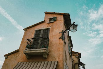 Low Angle Photography Of A Narrow Brown House