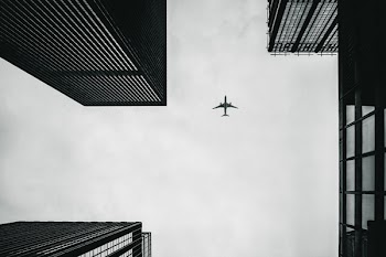 Low Angle Photography of Airplane And Buildings