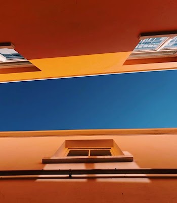 low-angle photography of brown concrete buildings under blue sky at daytime