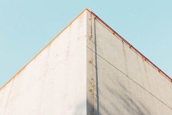 low angle photography of brown pipe near building