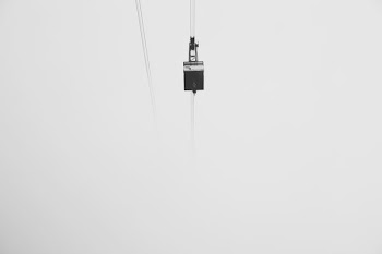 low-angle photography of cable car under gray skies