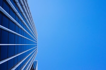 low-angle photography of curtain glass building under blue sky