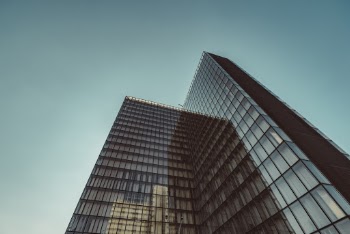 Low-angle Photography of Gray Glass High-rise Building Under a Calm Blue Sky